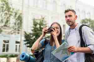 Free photo cute tourist couple taking pictures with camera