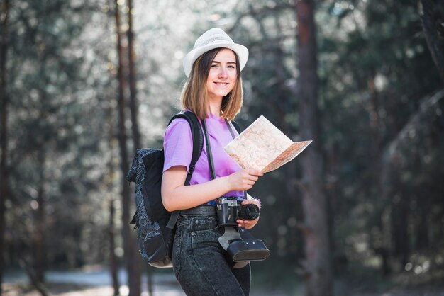 Cute traveller with map and camera