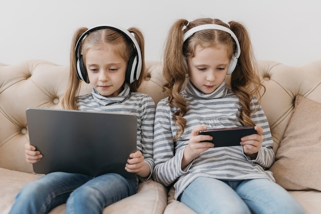 Free photo cute twins using digital devices