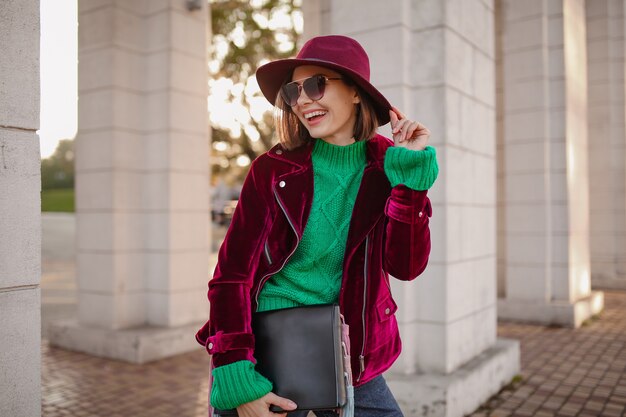 Cute woman in autumn style trendy outfit walking in street