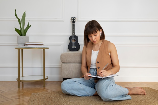 Free photo cute woman composing a new song on ukulele