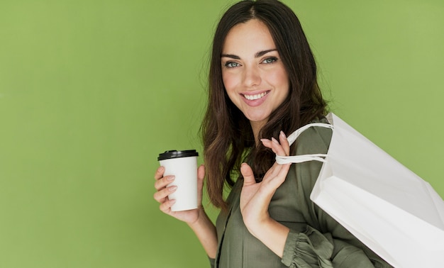 Foto gratuita donna sveglia su fondo verde che sorride alla macchina fotografica