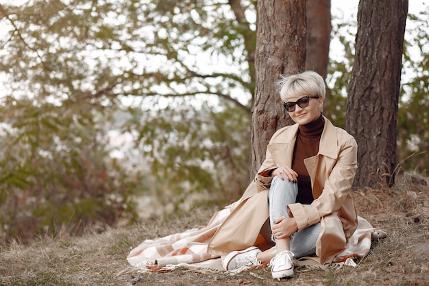 Симпатичная женщина отдыхает в осеннем парке