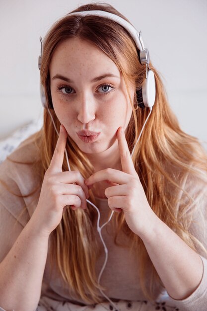 Cute woman in headphones touching cheeks