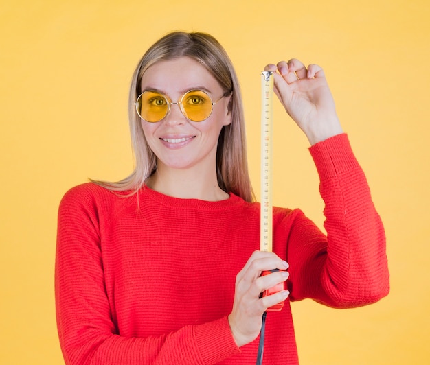 Cute woman holding measuring tape