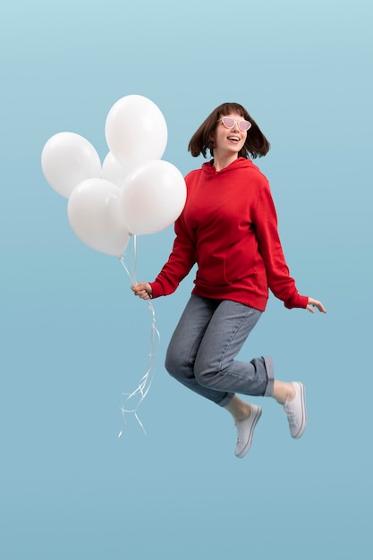 Cute woman jumping isolated on blue