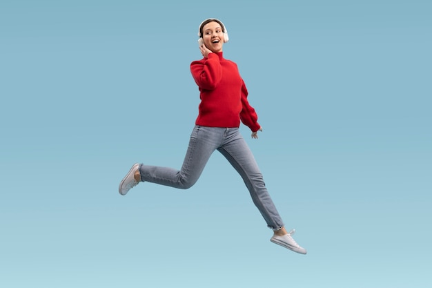 Cute woman jumping isolated on blue