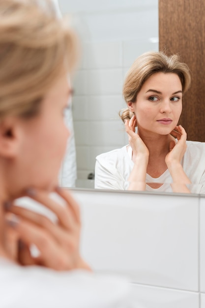 Cute woman looking in the mirror