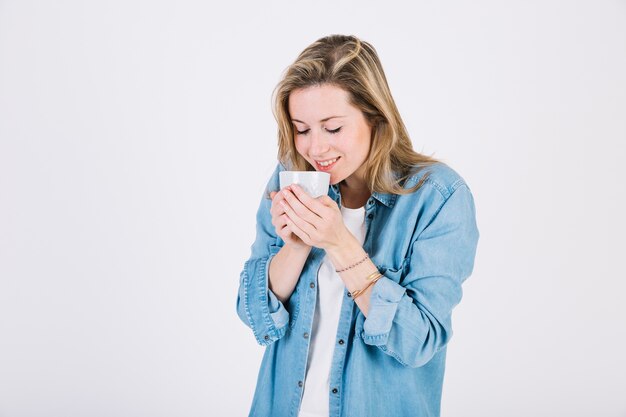 Cute woman smelling hot beverage