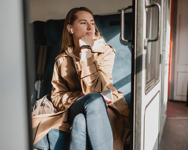 電車が駅を出るのを待っているかわいい女性