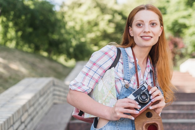 Free photo cute woman with old camera smiling