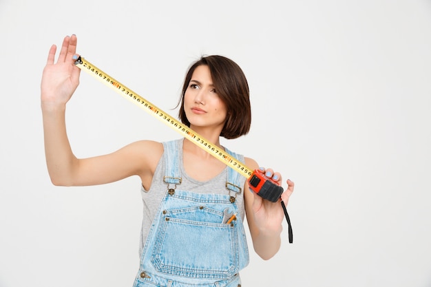 Foto gratuita la donna sveglia con la misura di nastro rinnova la casa