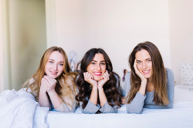 Free photo cute women on bed looking at camera