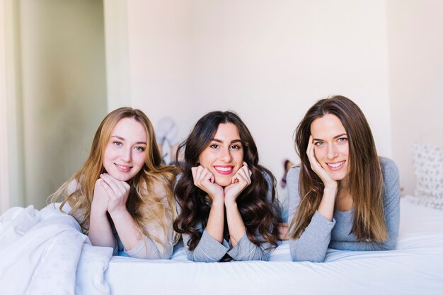 Cute women on bed looking at camera