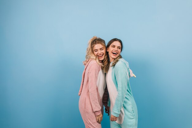 Cute women posing in kigurumi on blue wall