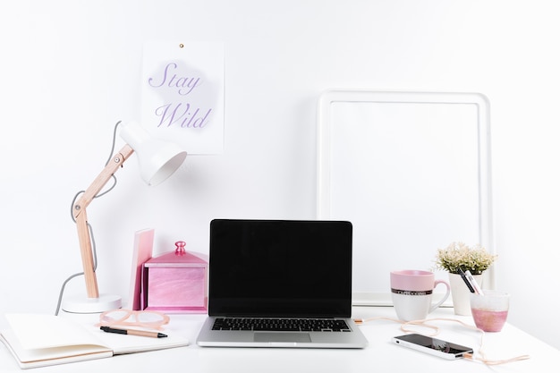 Cute workplace with laptop phone and notebook