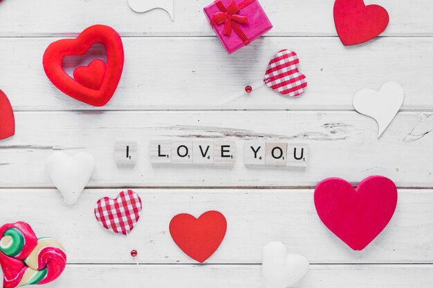 Cute writing and hearts on wooden background