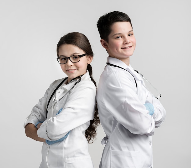 Cute young boy and girl dressed up as doctors