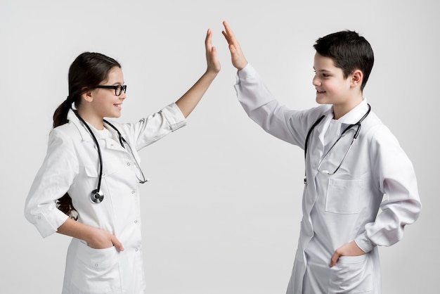 Симпатичные молодые мальчик и девочка, одетые как врачи