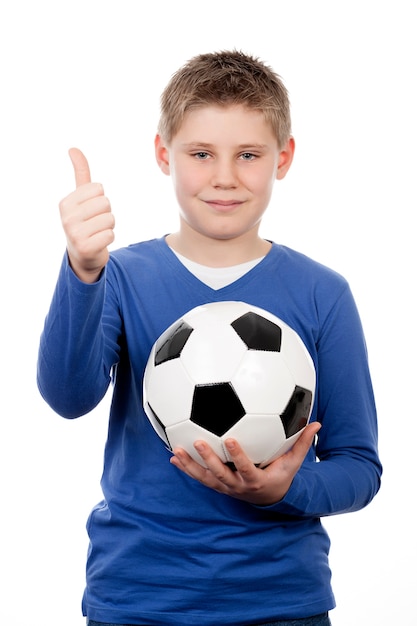 Foto gratuita ragazzo giovane sveglio che tiene un pallone da calcio