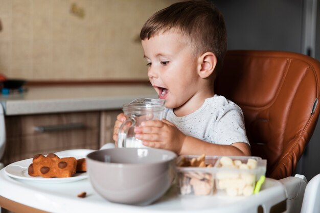 Cute young boy holding milk jar