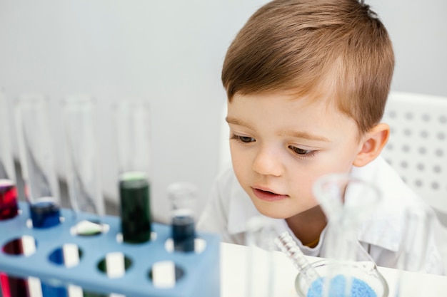 Cute young boy scientist doing experiments with test tubes