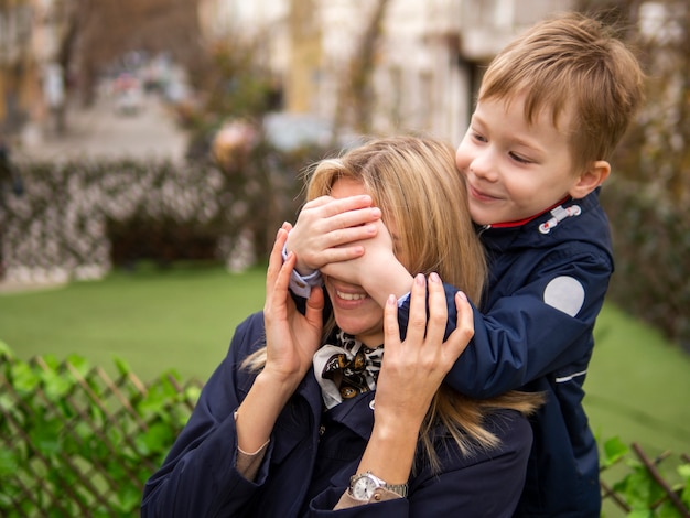 Cute young boy surprising his mother