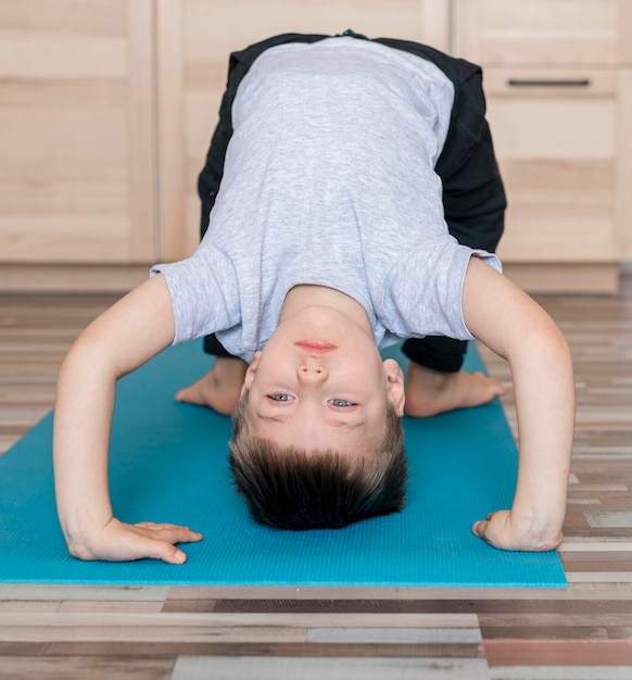 Cute young boy training at home