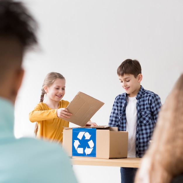 Cute young children learning how to recycle