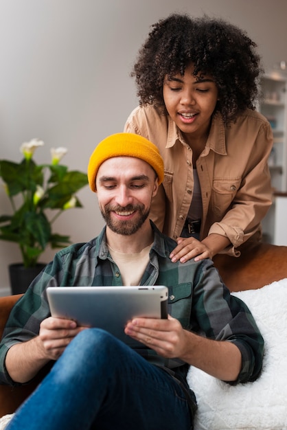 Free photo cute young couple looking on tablet