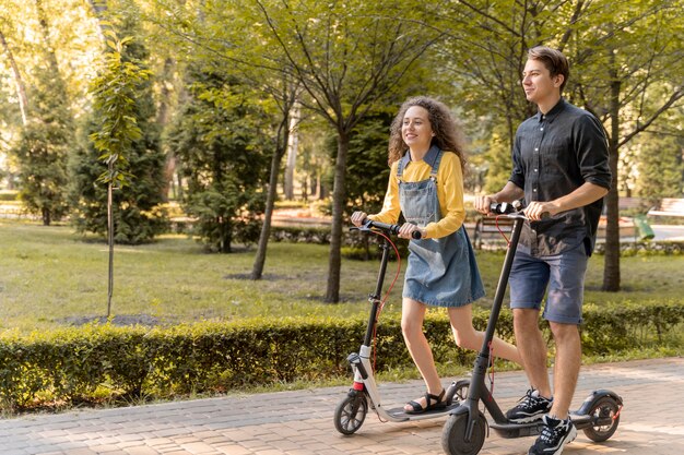 Cute young couple riding scooter outdoors