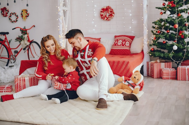 Cute young family sitting at home on a bed