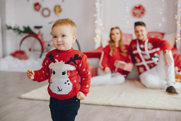 Cute young family sitting at home on a bed