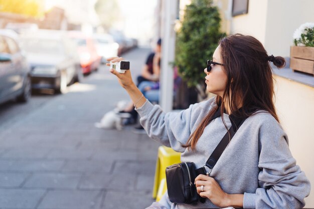 Cute, young female blogger posing on camera.