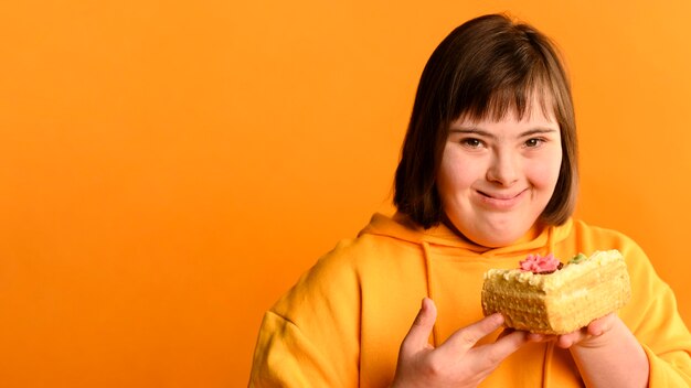 Cute young girl holding cake with copy space