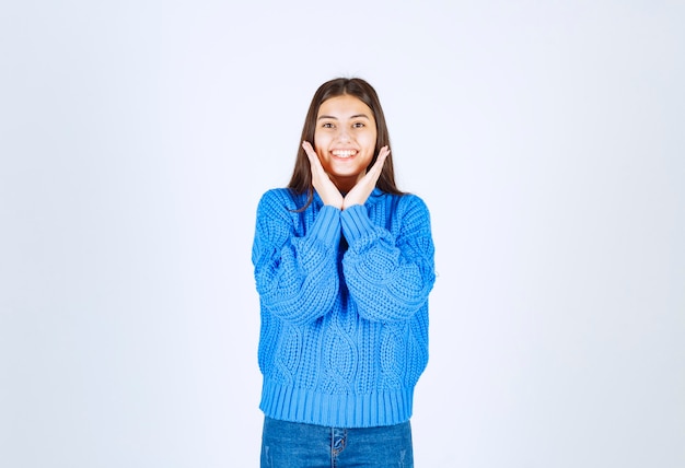 cute young girl holding cheeks with hands.