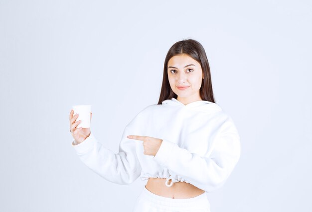 cute young girl model pointing at a plastic cup.