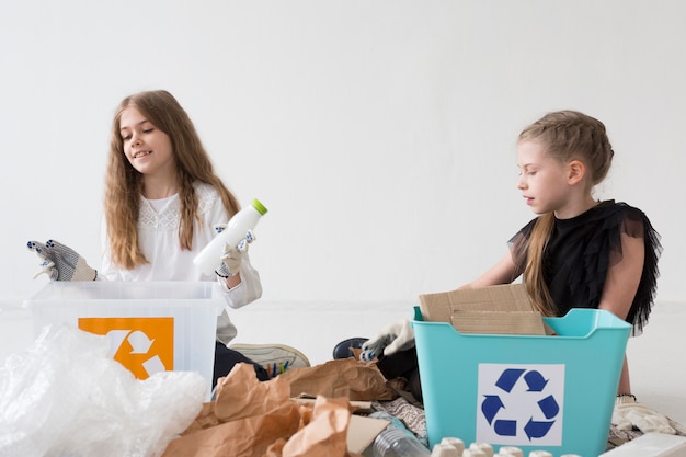 Free photo cute young girl recycling together