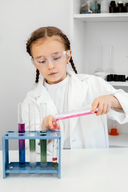 Cute young girl scientist doing experiments