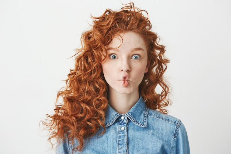 Free Photo cute young girl with foxy curly hair making funny face . copy space.