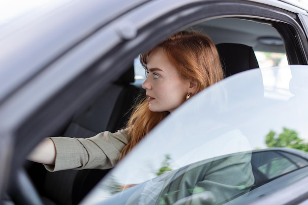 Cute young lady happy driving car Image of beautiful young woman driving a car and smiling Portrait of happy female driver steering car with safety belt