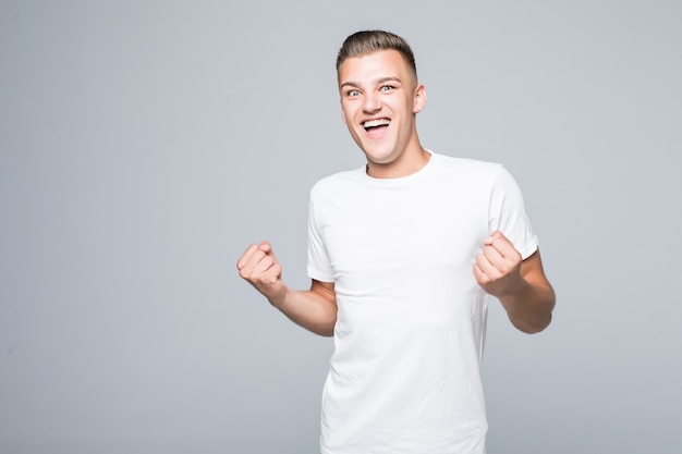 Cute young man boy shows happy victory sign isolated on white wall