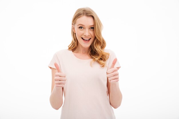 Cute young smiling woman showing thumbs up.