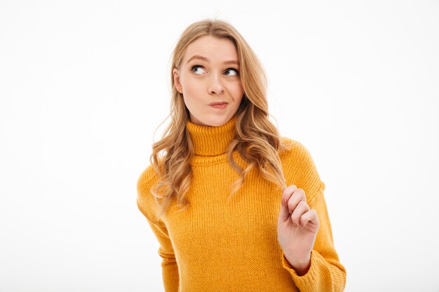 Cute young thoughtful lady standing isolated