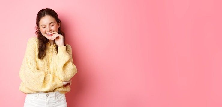 無料Photo かわいい若い女性は目を閉じて、ピンクに対して夢のように立っている褒め言葉から赤面する笑顔