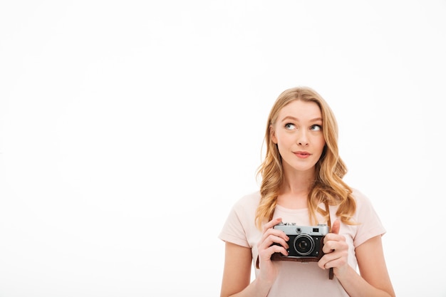 Macchina fotografica sveglia della tenuta della giovane donna.