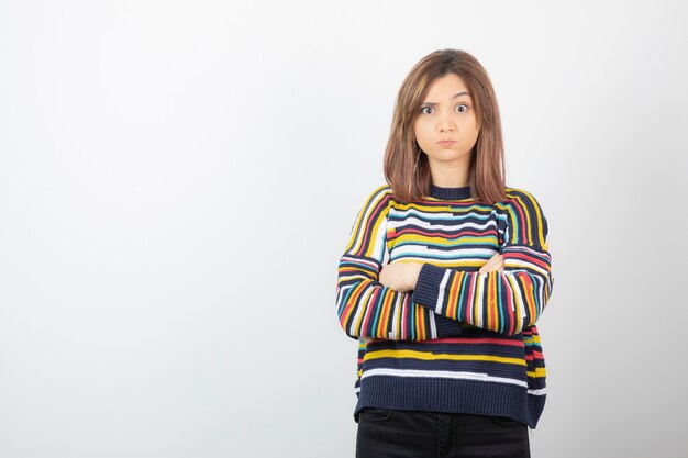 cute young woman model standing and posing with crossed arms.