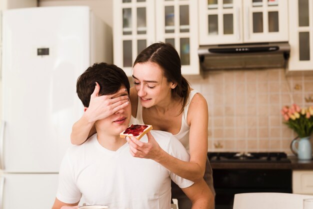 Cute young woman surprising boyfriend for breakfast