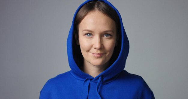 Cute young woman in thick cotton unlabeled hoodie smiling