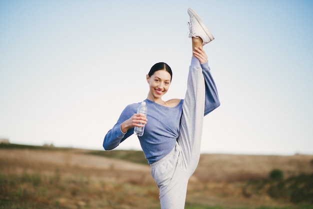 Free photo cute young woman training with bottle of water